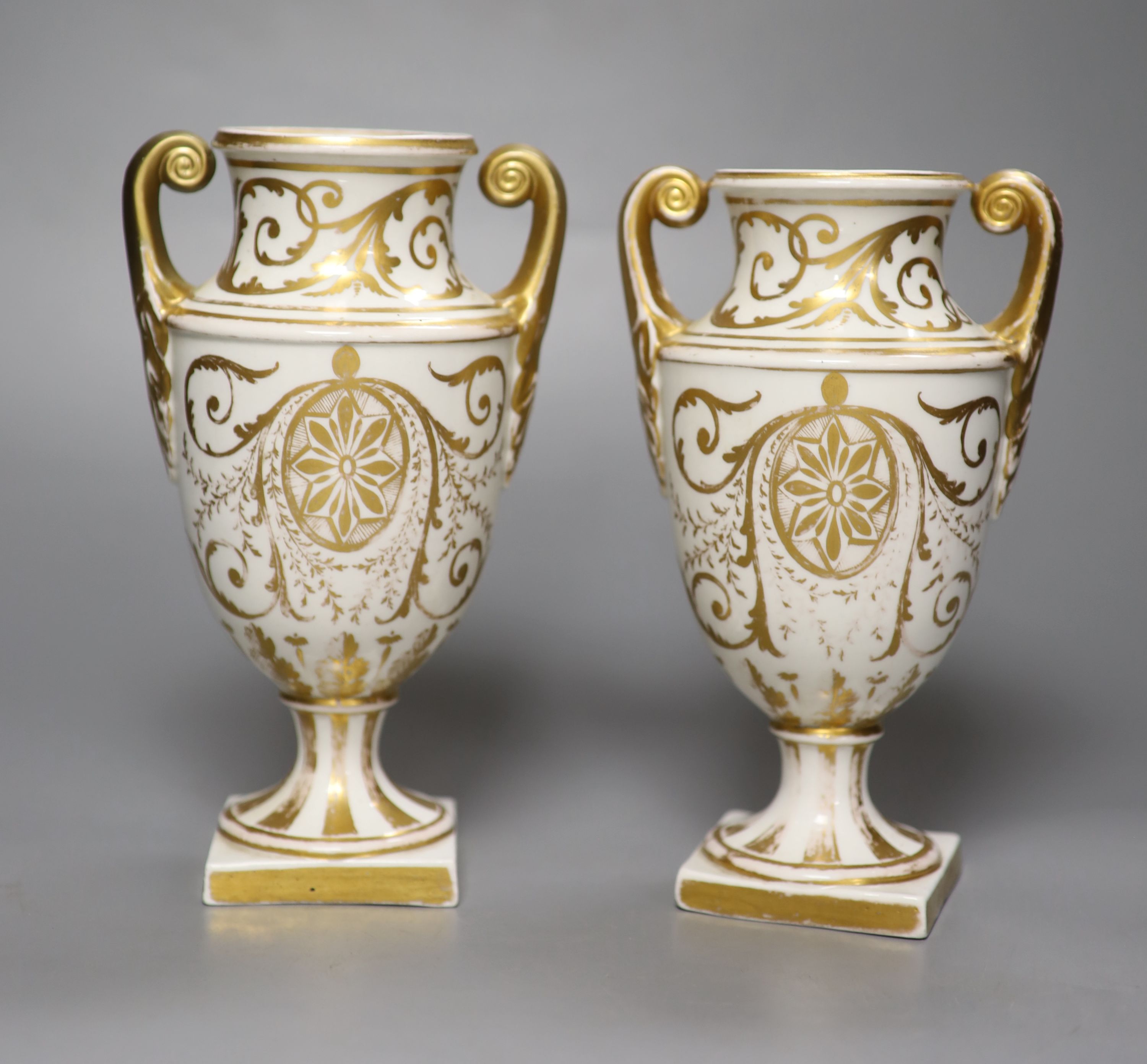 A pair of Regency porcelain two handled vases, painted with flowers, height 19cm